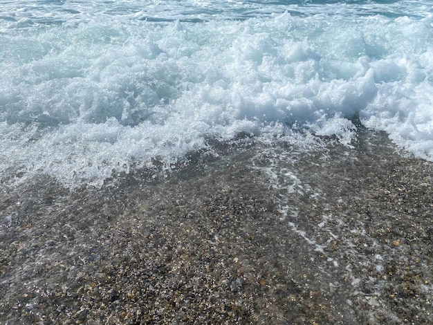 Schönes Meer mit Wellen, die warmes, funkelndes, klares blaues Wasser in einem warmen tropischen Orient spritzen