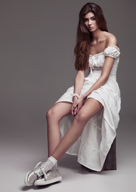Schönes Modemädchen des jungen Mädchens im weißen Kleid