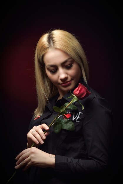 Foto schönes modemodell mit rose auf schwarzem hintergrund