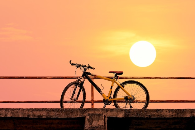 Schönes Mountainbike auf Betonbrücke mit buntem Sonnenlicht; Vintage Filter Style für Grußkarte und Postkarte.