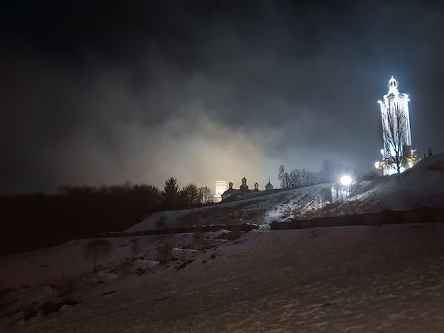 Schönes Nachtfoto von beleuchteten orthodoxen Kirchenkuppeln und bewölktem Himmel