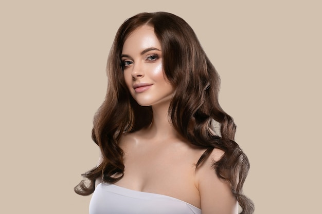 Schönes natürliches Haarhautfrauenporträt bilden langes lockiges Haar. Hintergrundfarbe braun