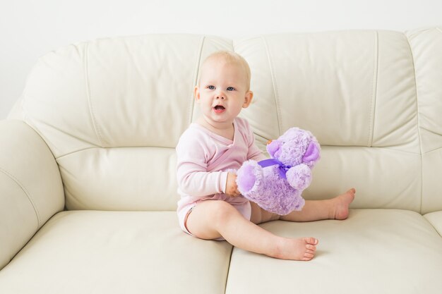 Schönes nettes weiches Baby, das auf Sofa sitzt