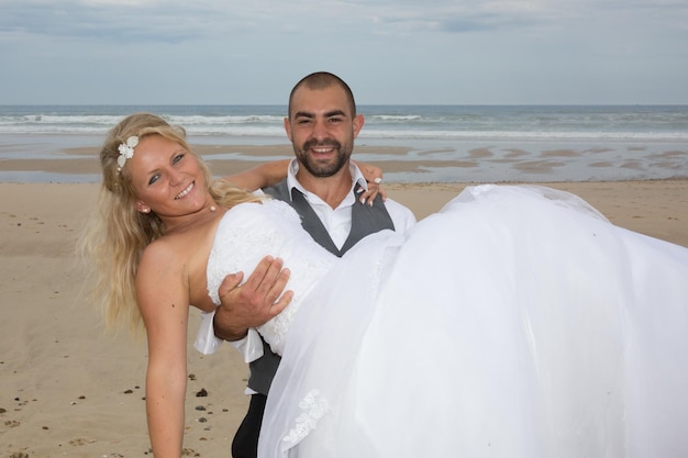 Schönes Paar am Strand im Hochzeitskleid