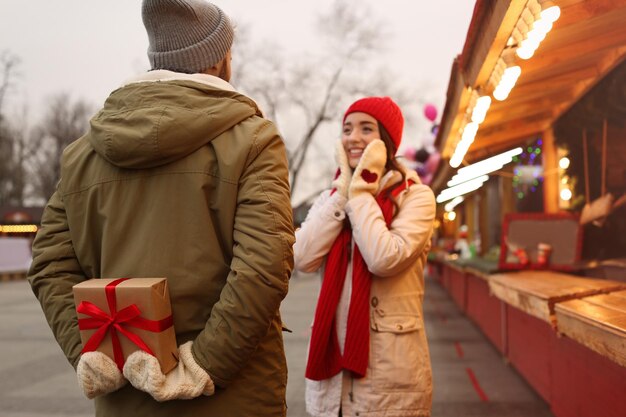 Schönes Paar auf der Wintermesse konzentriert sich auf das Weihnachtsgeschenk