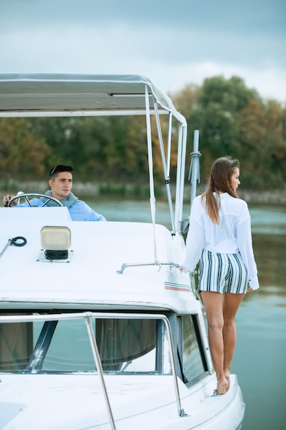 Schönes Paar, das auf der Yacht stillsteht. Segeln. Luxuslebensstil. Luxuriöses Leben für Frauen, die Reisen, Sommerferien genießen. Eine abenteuerliche Bootsfahrt machen