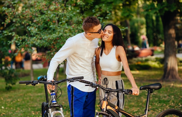 Schönes Paar, das mit seinen Fahrrädern im Park steht