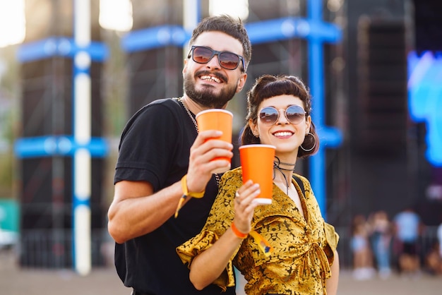 Schönes Paar, das sich beim Festival amüsiert Junge Freunde mit Bier auf der Strandparty Sommerferien