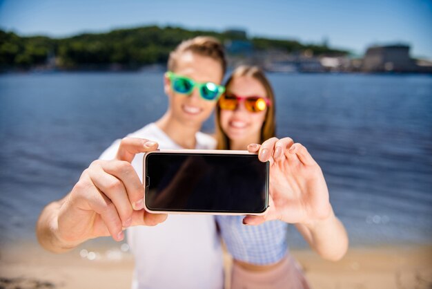 Schönes Paar, das zusammen am Strand aufwirft