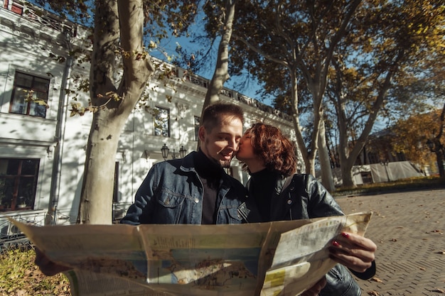 Schönes Paar im Urlaub mit Papierstadtplan für Wegbeschreibungen und Küssen