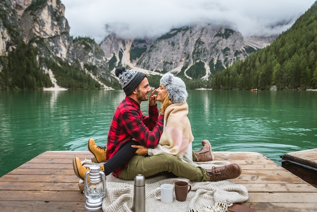 Schönes Paar junger Erwachsener, die einen Alpensee bei Braies Italien besuchen