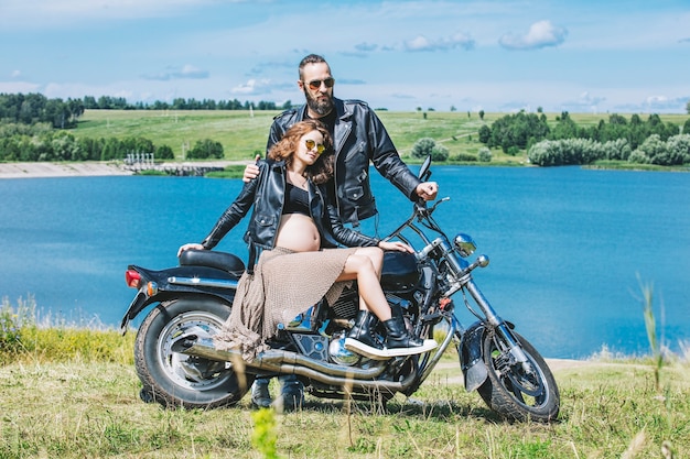 Schönes Paar Mann und Frau auf einem Motorrad auf einem Hintergrund