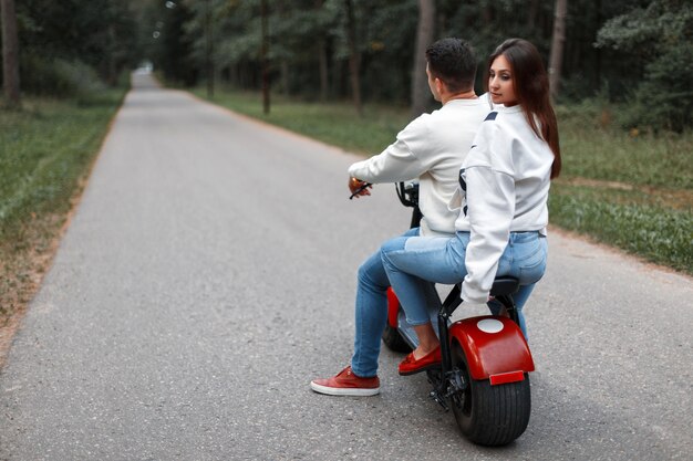 Schönes Paar Mann und Frau fahren auf einem modernen Elektrofahrrad im Park