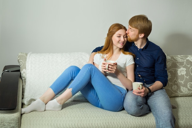 schönes Paar Mann und Frau sitzen auf dem Sofa zu Hause