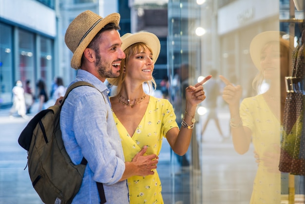 Schönes Paar von Liebhabern, die im Stadtzentrum einkaufen. Verspielte Touristen, die eine berühmte europäische Stadt besuchen