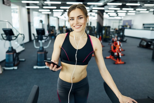 Schönes passendes Mädchen, das im Fitnessstudio aufwirft