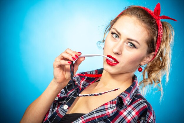 Schönes Pin-up stilisierte junge schwangere Frau in der Küche, die Saft trinkt