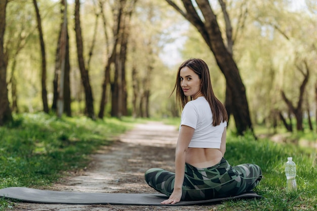 Schönes Plus-Size-Mädchen, das an einem sonnigen Sommertag Yoga in der Natur macht Körperpositiver Sport für Frauen