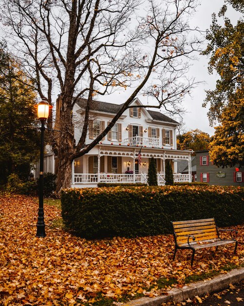 Schönes Privathaus mit einem hellorange belaubten Hof im Herbst