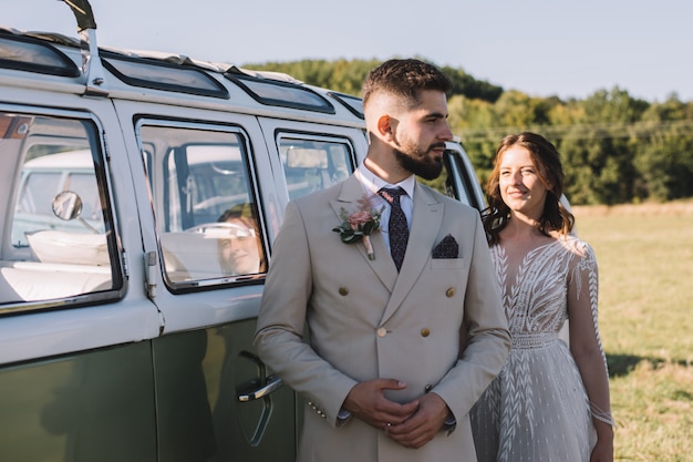 Schönes romantisches Hochzeitspaar von Jungvermählten nahe altem Auto