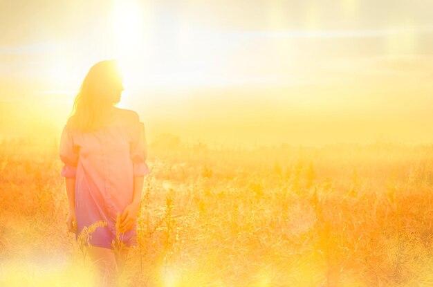 Schönes romantisches Mädchen im Freien Frau genießt mit Sonnenschein im Weizenfeld Kopieren Sie Platz für Ihren Text