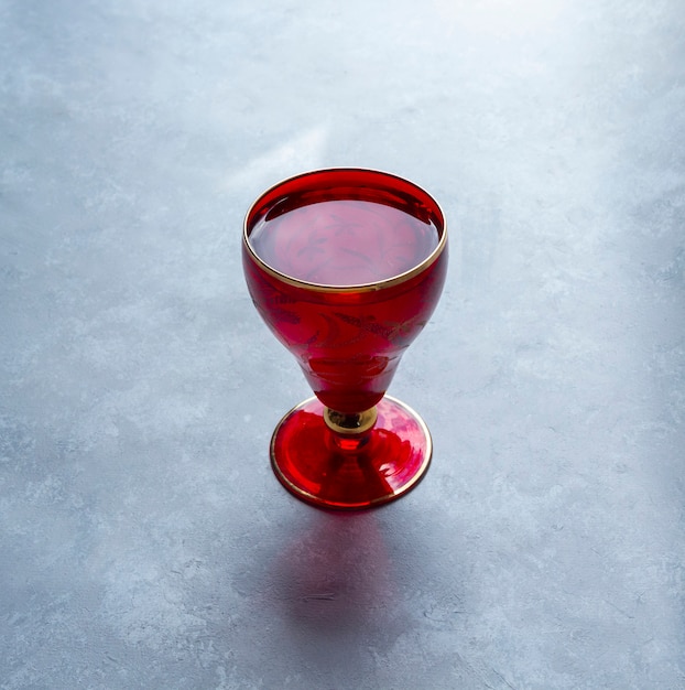 Schönes rotes Glas auf grauem Tisch.