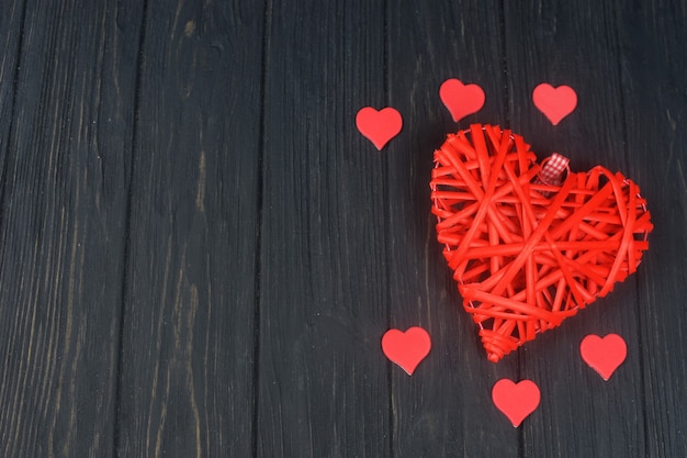 schönes rotes Herz des Weidengeflechts auf einem schwarzen Hintergrund am Valentinstag des Feiertagsfebruar