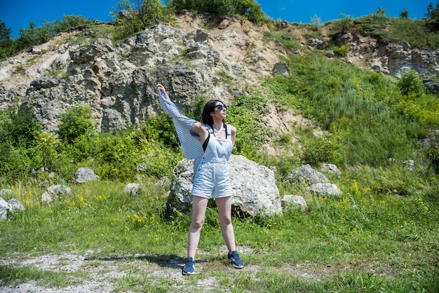 Schönes schlankes Mädchen, das in der Natur im Sommer aufwirft.