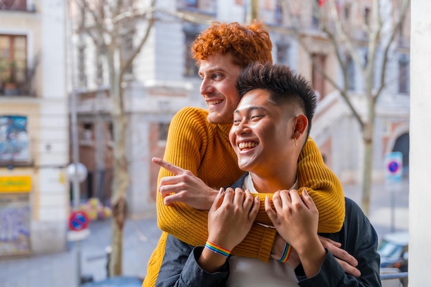 Schönes schwules paar, das zu hause auf dem sofa romantisch ist und sich auf dem balkon zu hause umarmt lgbt-konzept