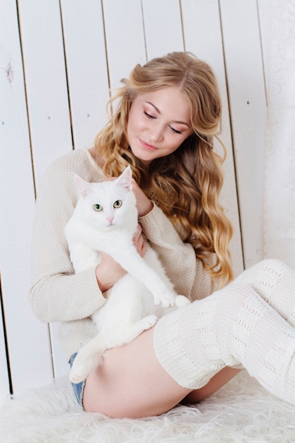 Schönes sexy blondes Sitzen zusammen mit der Katze