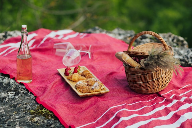 Schönes Sommerpicknick mit Erdbeerwein und Gebäck