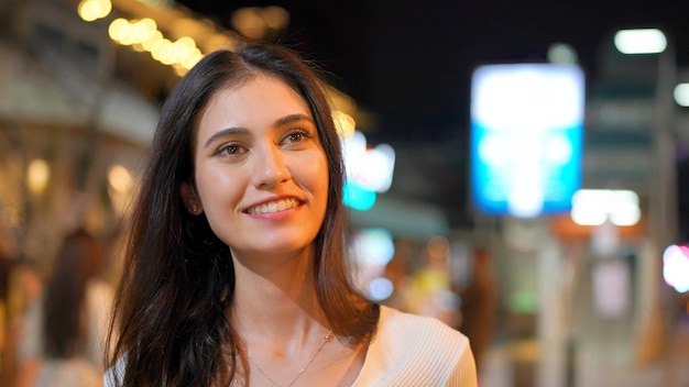 Schönes Stadtstraßenporträt der jungen Frau, gegen bokeh Licht.