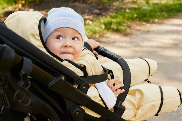 Schönes süßes gesundes Baby in einem Kinderwagen auf der Straße