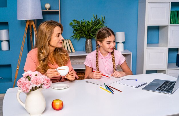 Schönes süßes Mädchen an der Grundschule, die Hausaufgaben zu Hause macht