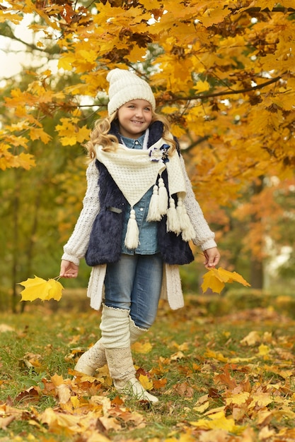 Schönes süßes Mädchen in weißen Stiefeln auf einem täglichen Spaziergang im Park