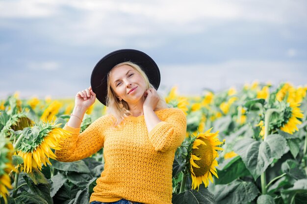 Schönes süßes sexy Mädchen in einer gelben Jackenjeans und einem schwarzen Hut