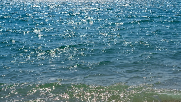 Schönes türkisfarbenes Meer mit kleinen Wellen an einem hellen sonnigen Tag