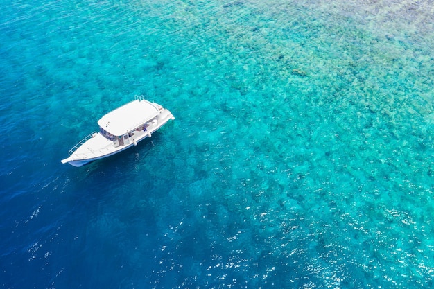 Schönes türkisfarbenes Meerwasser mit Boot. Tropisches Korallenriff über Luftbild, Meereslagune