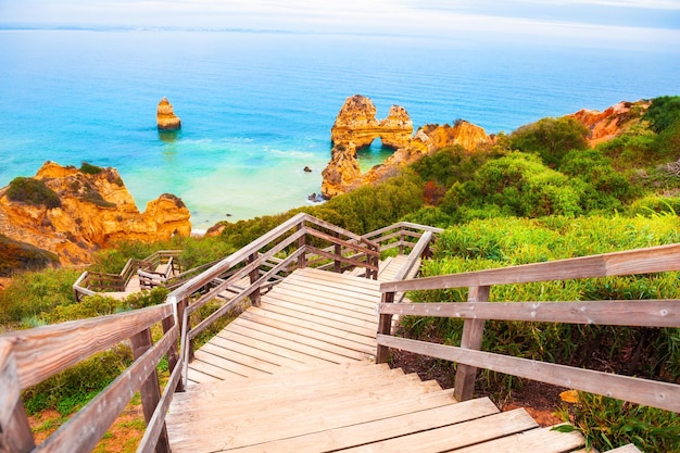 Schönes Ufer des Atlantiks mit Treppe zum Strand. Algarve, Portugal. Berühmtes Reiseziel