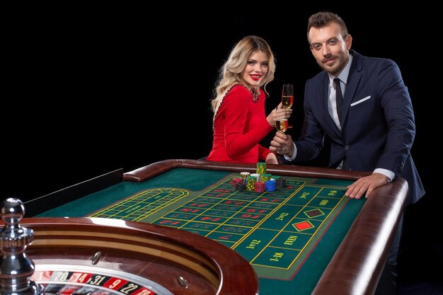 Schönes und gut gekleidetes Paar, das Roulette im Casino spielt