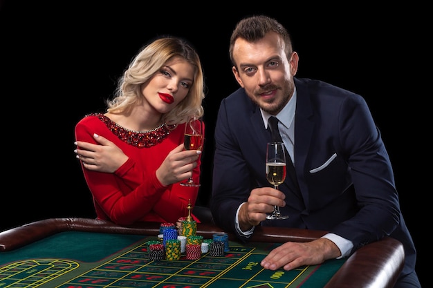 Schönes und gut gekleidetes Paar, das Roulette im Casino spielt
