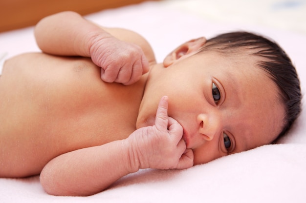 Schönes und schönes Baby auf einem rosa Handtuch