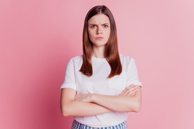 Schönes verärgertes Mädchen stirnrunzelnd beleidigtes Gesicht isoliert über rosa Hintergrund