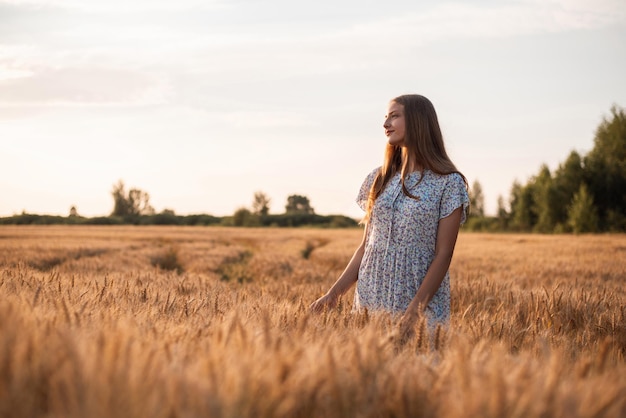 Schönes verträumtes Mädchen auf dem Gebiet des Roggens bei Sonnenuntergang Porträt eines Teenager-Mädchens, das die Schönheit der Natur bewundert