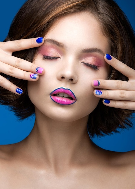 Schönes vorbildliches Mädchen mit hellem Make-up und farbigem Nagellack Schönheitsgesicht Kurze bunte Nägel