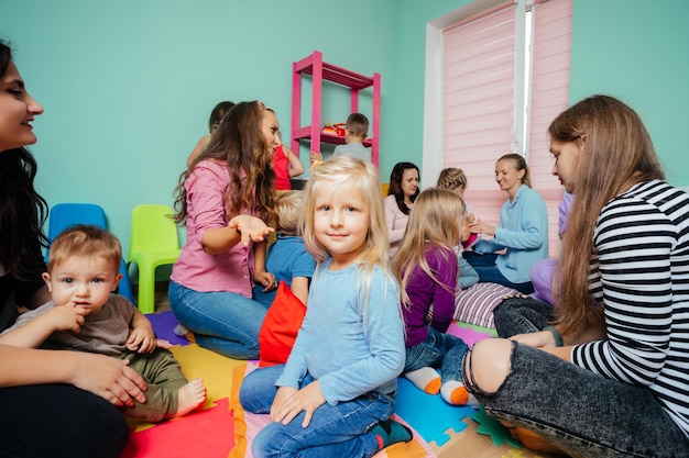 Schönes Vorschulmädchen bei einem Treffen von Müttern mit Kindern