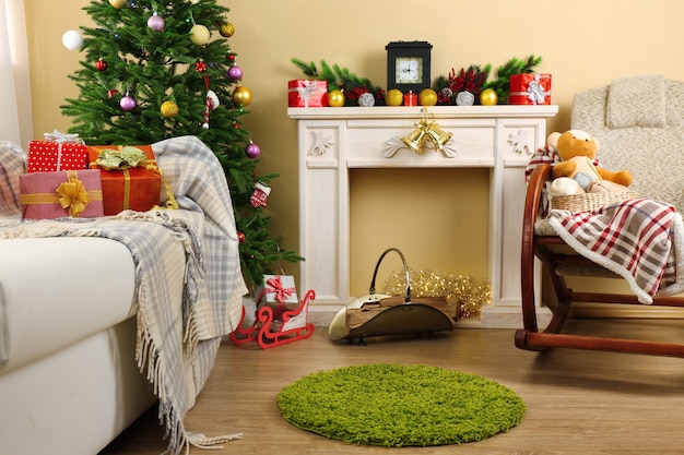 Schönes Weihnachtsinterieur mit dekorativem Kamin und Tannenbaum