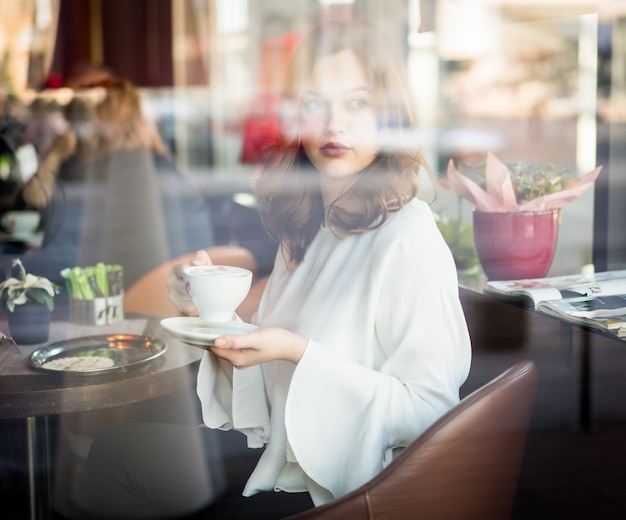 Schönheit, die beim Restaurantdenken sitzt