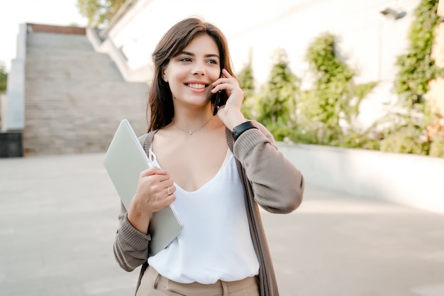 Schönheit, die draußen Telefon im Stadtpark verwendet