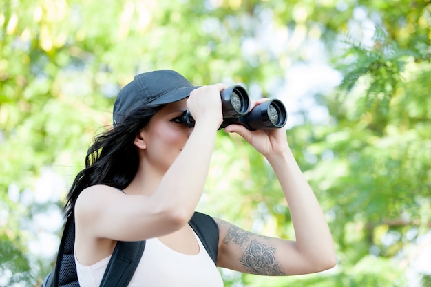 Schönheit, die durch Ferngläser beim Wandern der Reise schaut